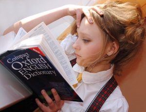 girl reading dictionary to learn LSAT vocabulary words